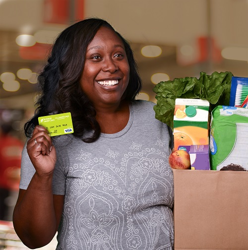Buckeye member holding bag of groceries and rewards card