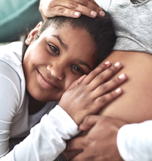 Child next to Pregnant Belly Smiling