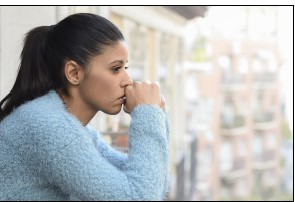 Woman looking off, hands in front of face, Worried