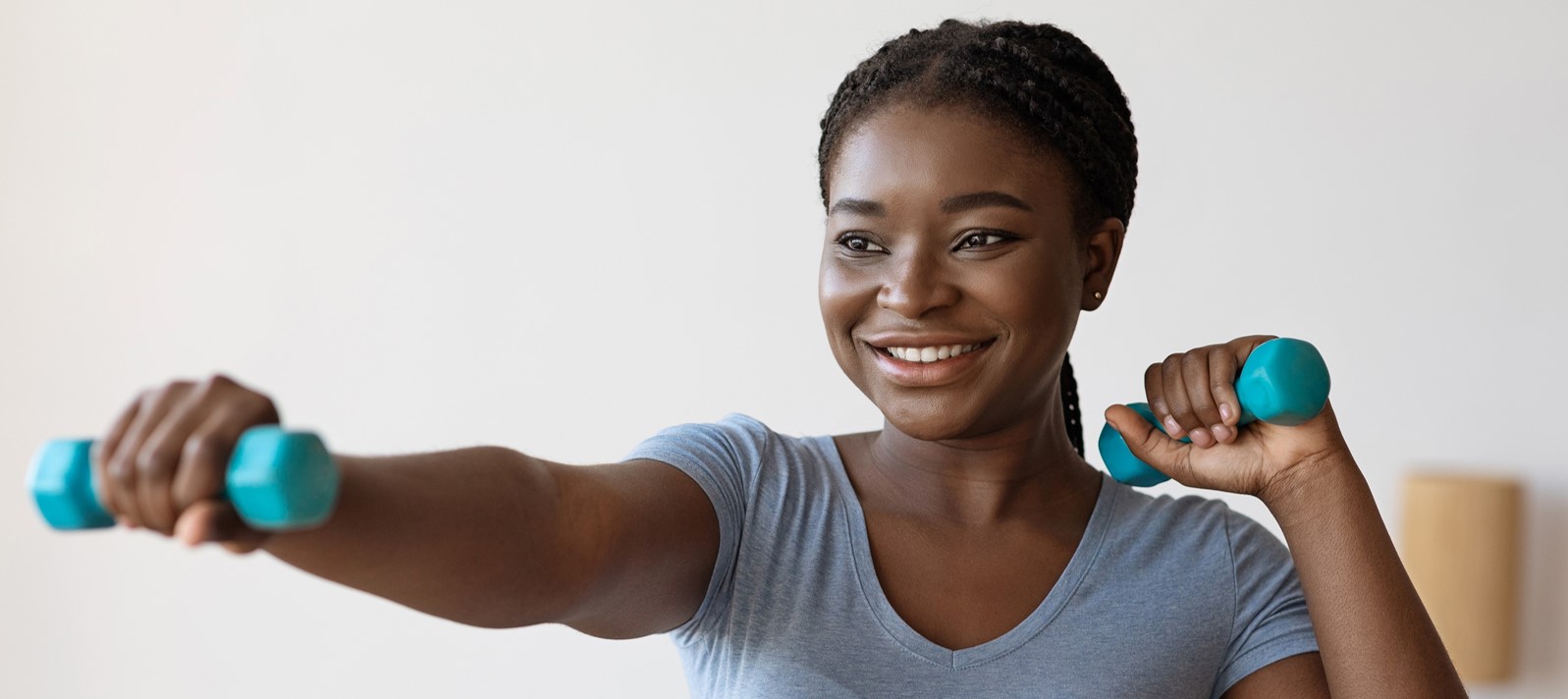 Woman working out with weights smiling