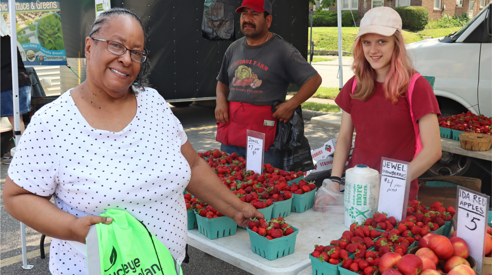 Buckeye Members pose for a picture next to a fruit stand.