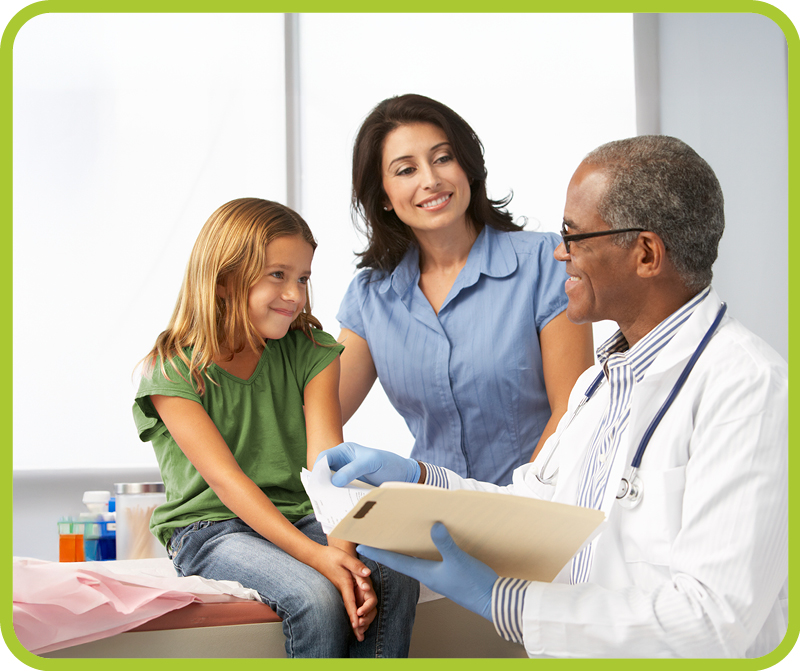 Male doctor talks with mother and young girl patient