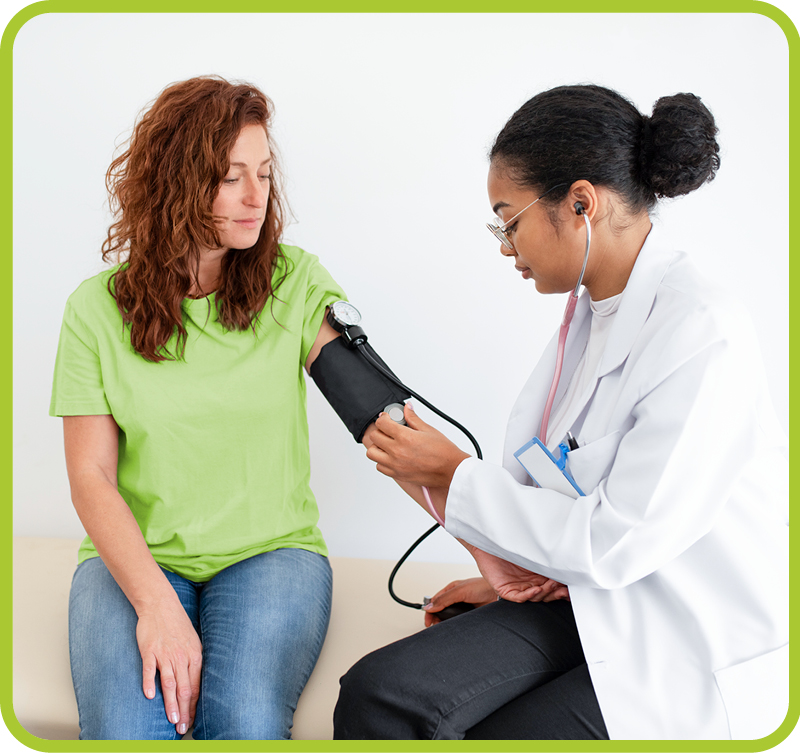 Female doctor checking blood pressure on female patient