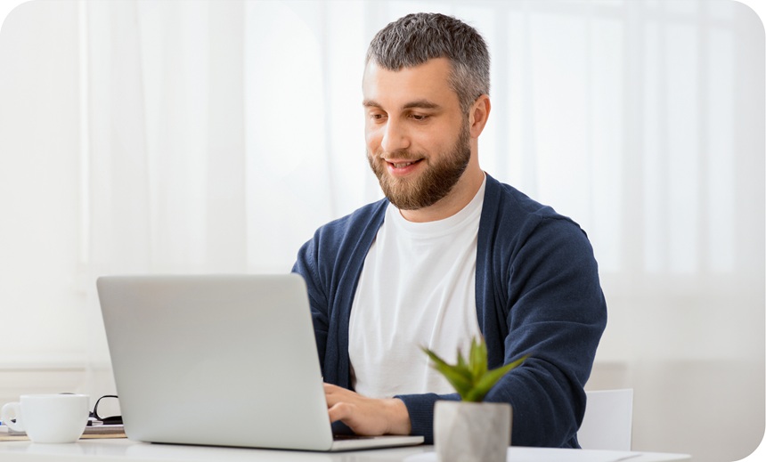 A man types on his laptop. 