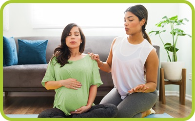 Doula helps pregnant woman with breathing exercises