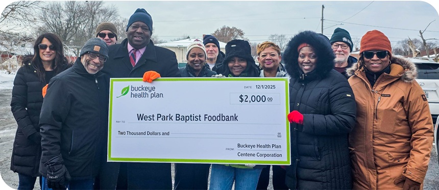 Buckeye staff and members of West Park Baptist Food Bank stand behind a large check.
