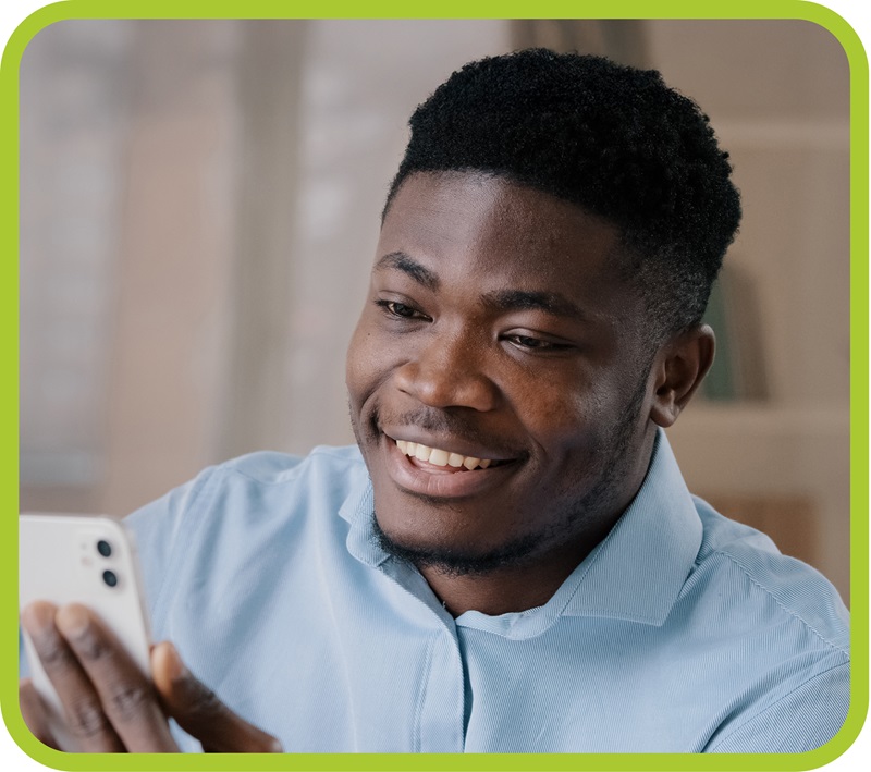Man smiles while looking at his phone