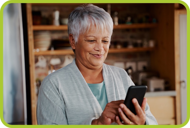 Lady with gray hair looks down while using her smart phone