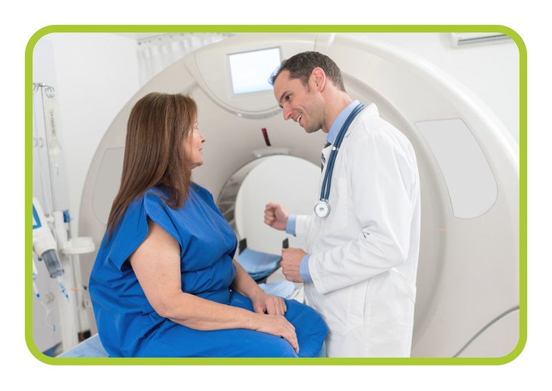 woman patient talks to male MRI technician in front of MRI machine