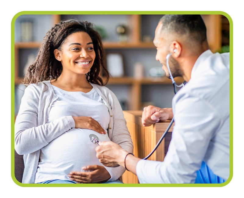 Male provider with stethiscope checks on pregnanct patient